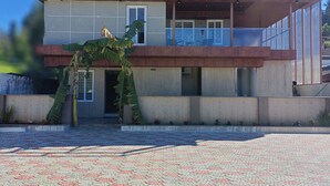 A two-story building with a flat roof and a large entrance. - Villa Euphoria (Ootacamund)