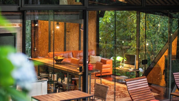 A modern interior with a dining area, seating, and a staircase. - Chale de Vidro nas montanhas (Itamonte)