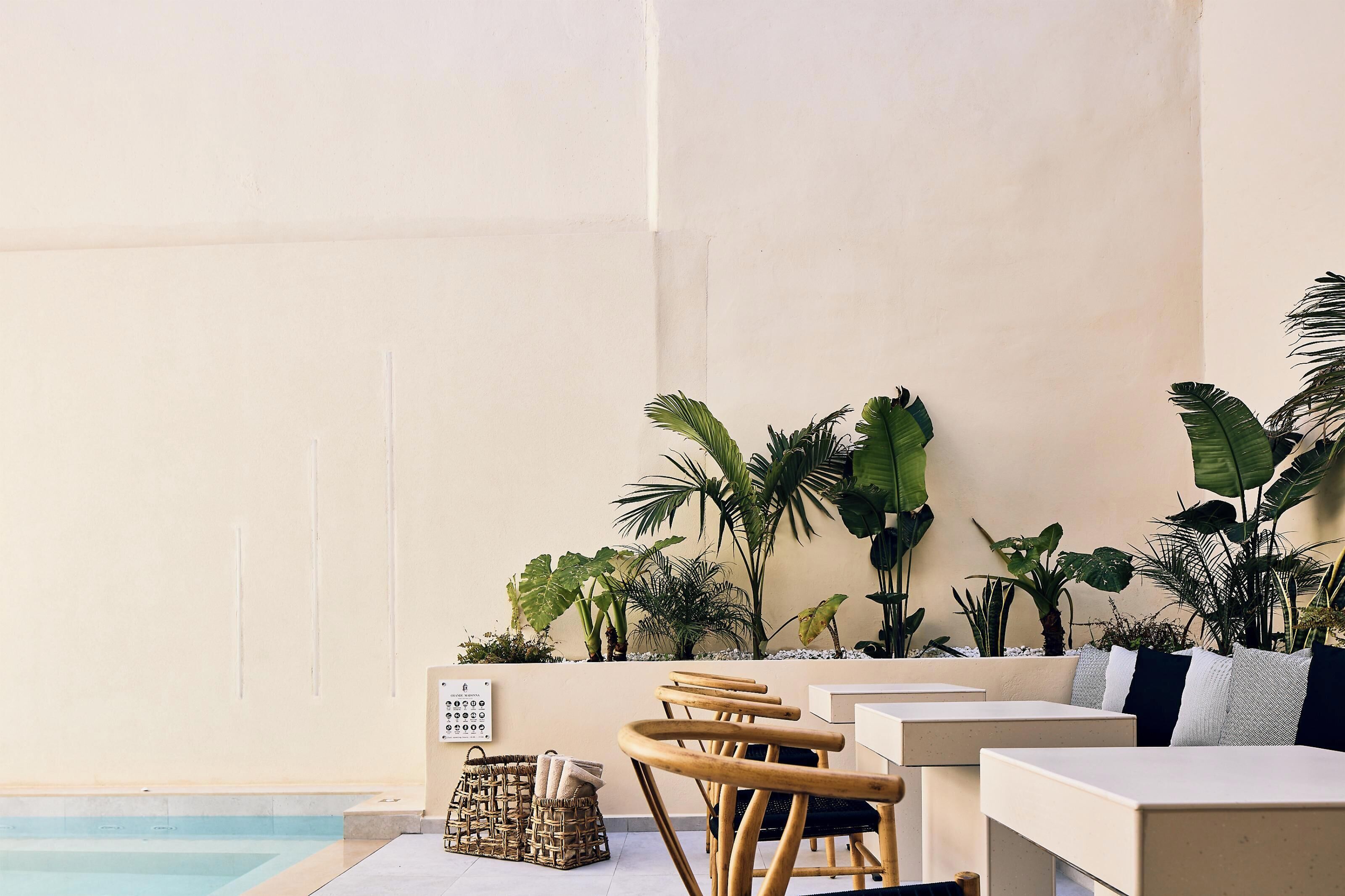 Un espace aménagé au bord de la piscine, avec des sièges, des plantes et un panneau de commande.