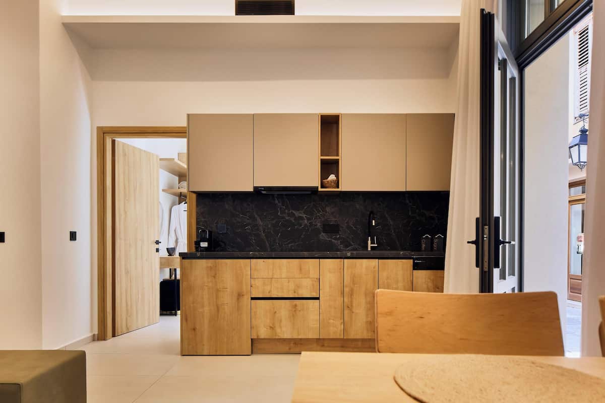 Une cuisine moderne avec des meubles en bois, un plan de travail en marbre noir et un four encastré.