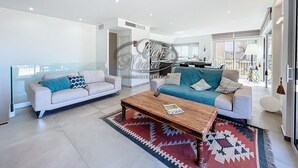 Ein modernes Wohnzimmer mit zwei Sofas, einem Couchtisch und einem gemusterten Teppich.