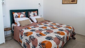 A bedroom with a bed, a nightstand, a wall-mounted lamp, and a framed artwork. - BRAND-NEW SELF-CONTAINED STUDIO WITH GARDEN IN MARINE AREA (Corbara)