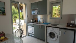 A compact kitchen with a washing machine, a microwave, and a sink. - BRAND-NEW SELF-CONTAINED STUDIO WITH GARDEN IN MARINE AREA (Corbara)