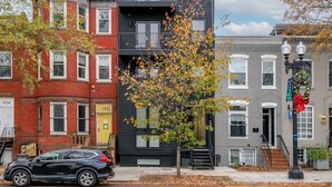 A modern building with a flat roof and a tree in front. - Modern Capitol Hill Apartment – 3 Min Walk to Metro! (Washington)