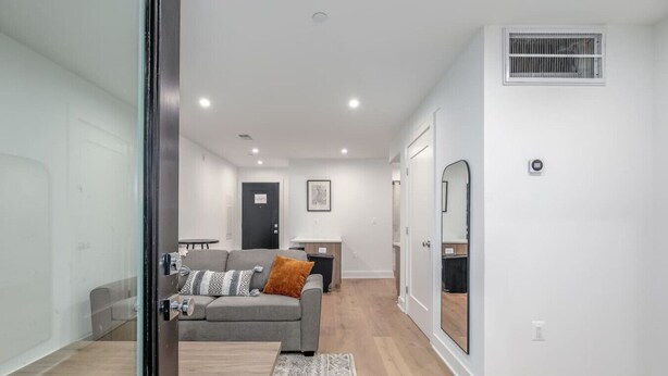A modern living room with a grey sofa, a coffee table, and a patterned rug. - Modern Capitol Hill Apartment – 3 Min Walk to Metro! (Washington)