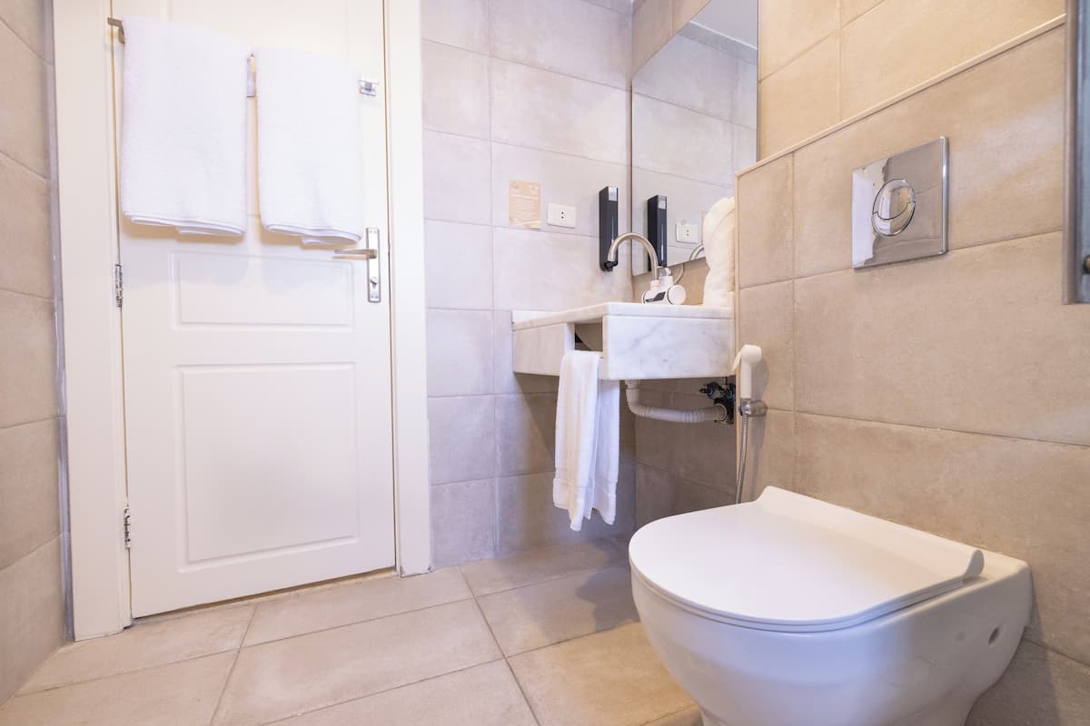 A modern bathroom with a toilet, sink, and towel rack.