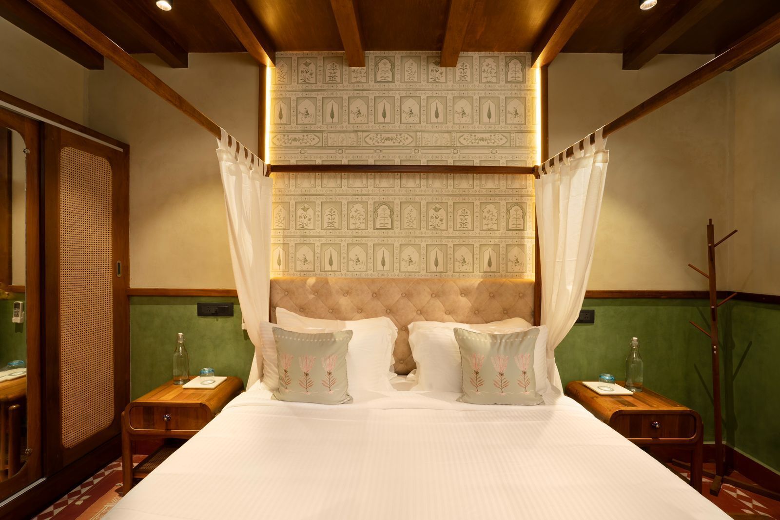 Une chambre à coucher avec un grand lit, un baldaquin et une tête de lit décorative.