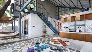 Ein modernes Interieur mit Treppe, Küchenbereich und einer Sitzecke mit Gesellschaftsspielen.