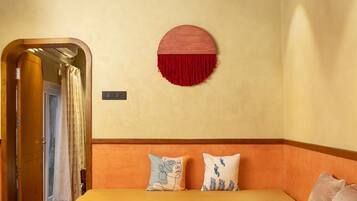 A room with a bed, a ceiling fan, a circular wall decoration, and a patterned rug.