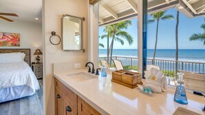 A modern bathroom with a large window, a sink, and a mirror.