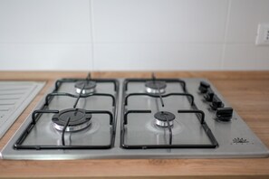 Une cuisine équipée de quatre brûleurs à gaz et d’une plaque de cuisson.