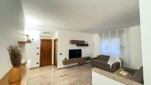 A modern living room with a flat-screen TV, a sofa, and a coffee table. - Casa Micio - MS 3 NT by Ca-sa Check (Chioggia)