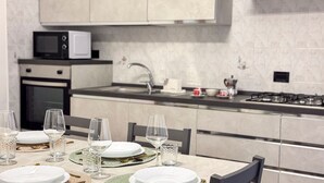 A modern kitchen with a dining area set for a meal. - Casa Micio - MS 3 NT by Ca-sa Check (Chioggia)