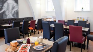 A dining area with tables, chairs, and breakfast items. - Klosterhotel Lehnin (Kloster Lehnin)