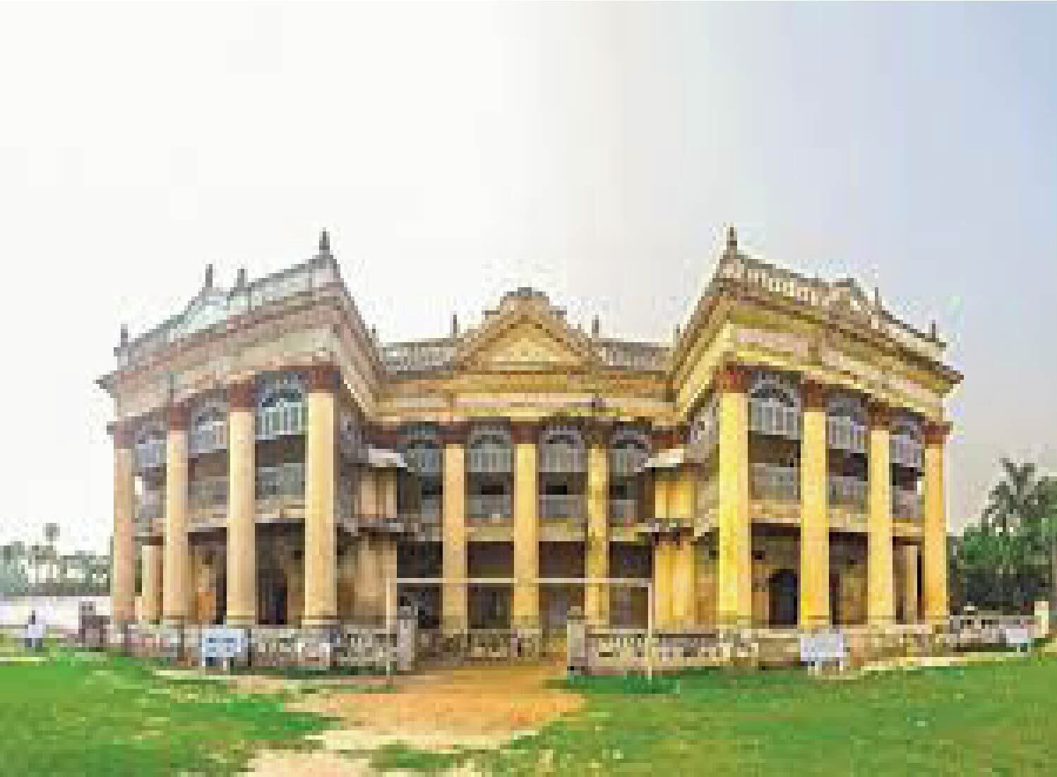 A large, classical-style building with multiple columns and a symmetrical facade.