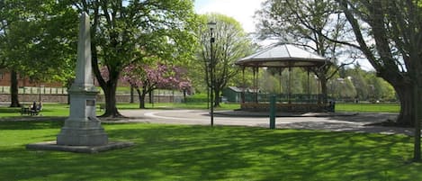 Un parc agrémenté d’un monument, d’un kiosque et d’un sentier sinueux.