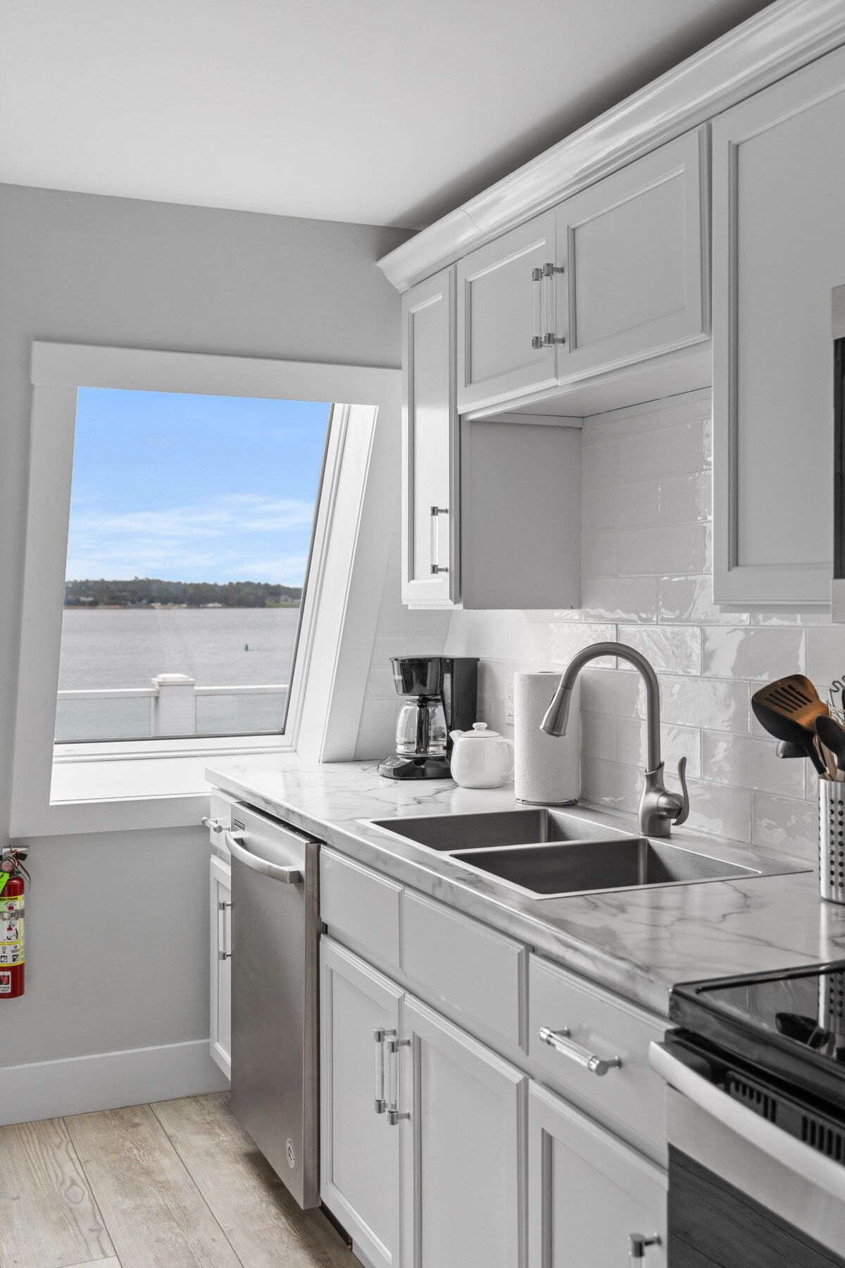 Una cocina moderna con vista a un lago, una cafetera y un lavamanos.