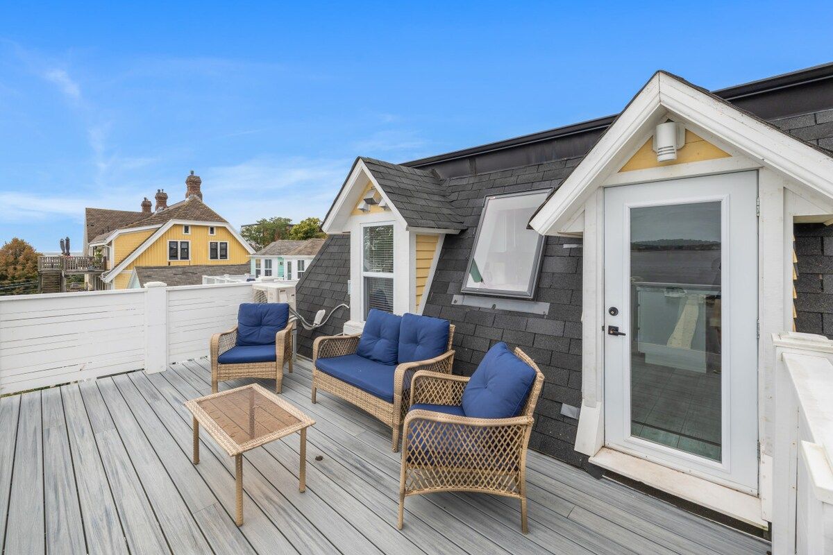 A deck with wicker furniture and a glass door.