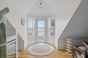 Una habitación con vista al mar, un tapete redondo y una decoración de pez de madera.