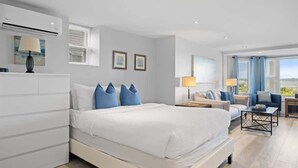 A modern bedroom with a large bed, a sofa, a coffee table, and a desk.