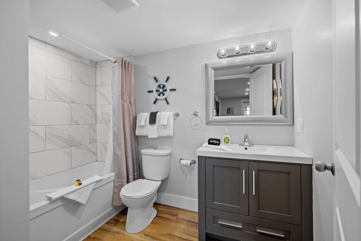 Une salle de bain moderne équipée d’une douche, de toilettes, d’un meuble-lavabo et d’un miroir.