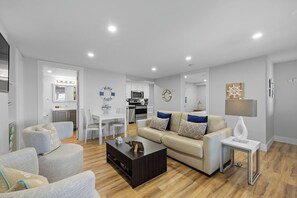 Un salon moderne comprenant un canapé, une table basse et un coin repas avec des chaises et une table.