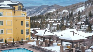 A resort with a pool, outdoor seating, and snow-covered mountains in the background. - Spectacular Ritz Carlton Penthouse Residence in Vail. Two levels!! (Vail)