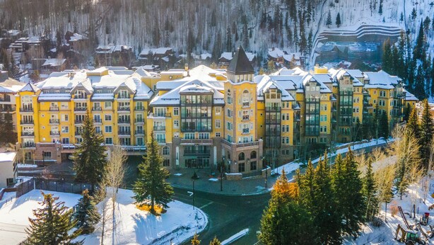 A multi-story hotel with a central courtyard, surrounded by snow-covered trees and a mountainous backdrop. - Spectacular Ritz Carlton Penthouse Residence in Vail. Two levels!! (Vail)