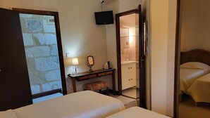 A hotel room with two beds, a desk with a mirror, a TV, and a bathroom visible through an open door. - Le Plessis-Lepage "L'Atelier" **** Calm-Space-Green at Azay-le-Rideau (Azay-le-Rideau)