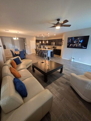 Ein modernes Wohnzimmer mit Sofa, Couchtisch und Fernseher.