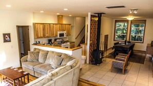 Un salon comprenant un canapé, une table basse et un coin cuisine avec des meubles en bois et un four à micro-ondes.