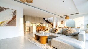 A modern living room with a sofa, coffee table, and artwork on the wall. - Villa Janoor by GORO (Keroboken Kelod)