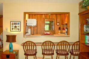 Enjoy meals in this inviting dining area with a view of lush greenery outside.