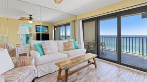 A spacious living area with a sofa, a wooden bench, and a ceiling fan.