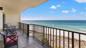 A balcony with wicker furniture and a view of the ocean.
