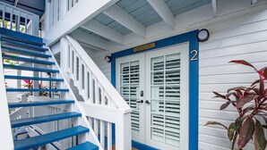 A staircase with blue steps leading to a white door with a number '2' sign.