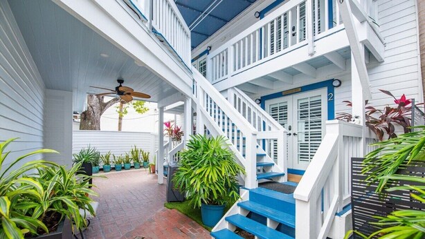 A multi-level wooden house with a blue staircase and white railings. - Citrus Queen at Custom House Inn | Ideal Location (Key Wets)