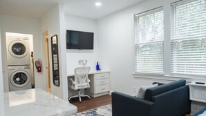 A modern living room with a sofa, a desk, and a washing machine. - Cozy studio in Columbia with WiFi, AC (Columbia)