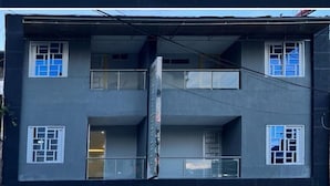 A multi-story building with a balcony on the second floor and a door on the ground floor. - HOTEL MAGISTRAL SUITER (Quibdó)