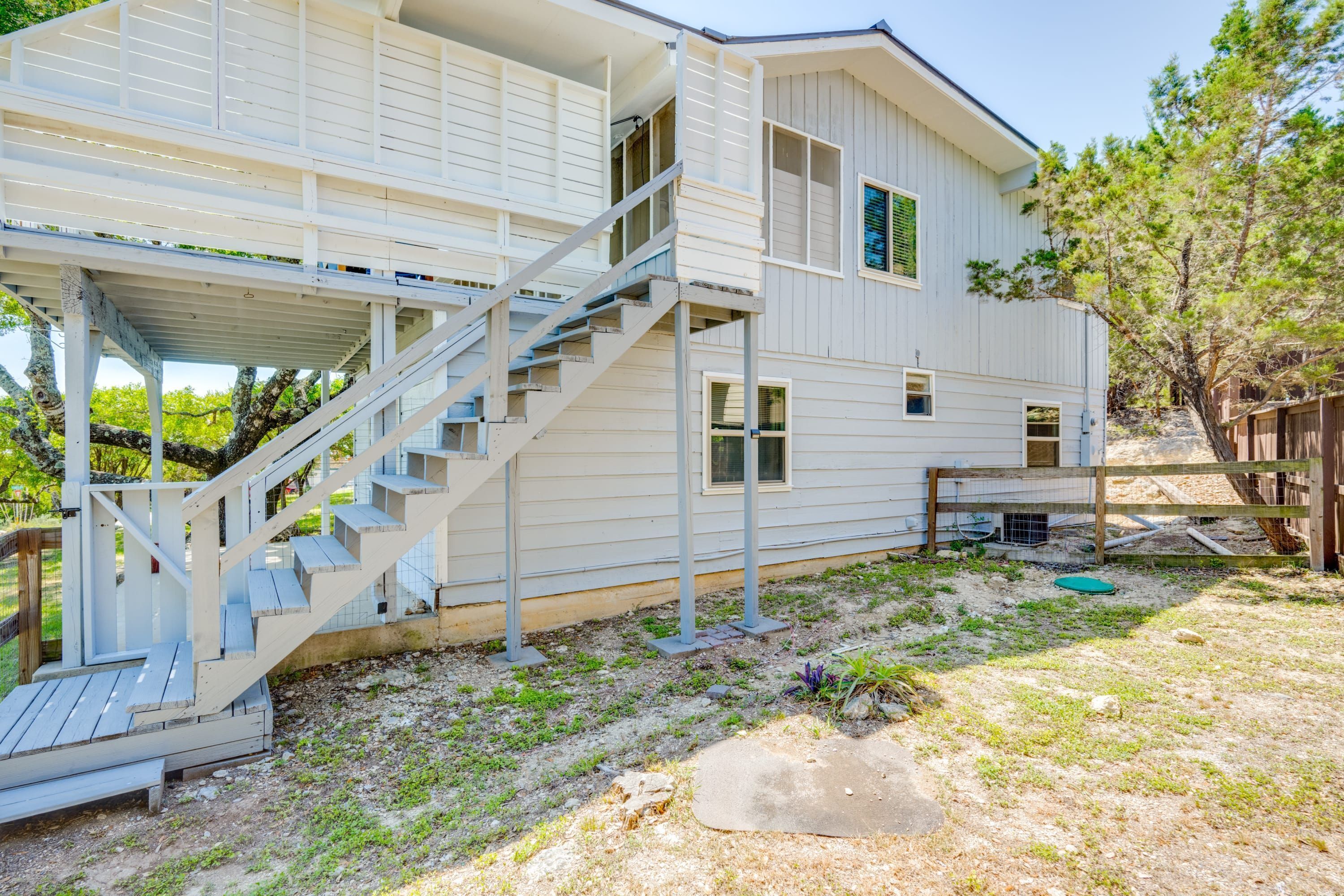A two-story house with a covered porch and a staircase leading to the upper floor.