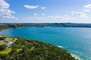 A coastal area with a clear blue sea, a parking lot, and dense greenery. - 4 3 two King Beds Perfect Sunset Lake Views Pickleball Fire pit Lvl2 EV POA Pool (Canyon Lake)