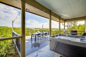 An outdoor deck with a hot tub, dining table, and chairs. - 4 2 Firepit hot tub Scenic Views L2 EV Charger (Dripping Springs)