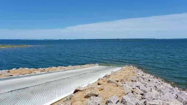 En kyststi med gelænder og stenede omgivelser, der fører ned til havet.