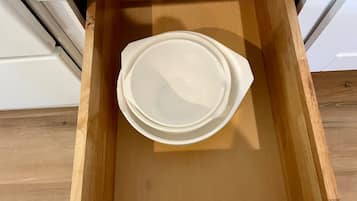 A wooden drawer with a white plastic container inside.