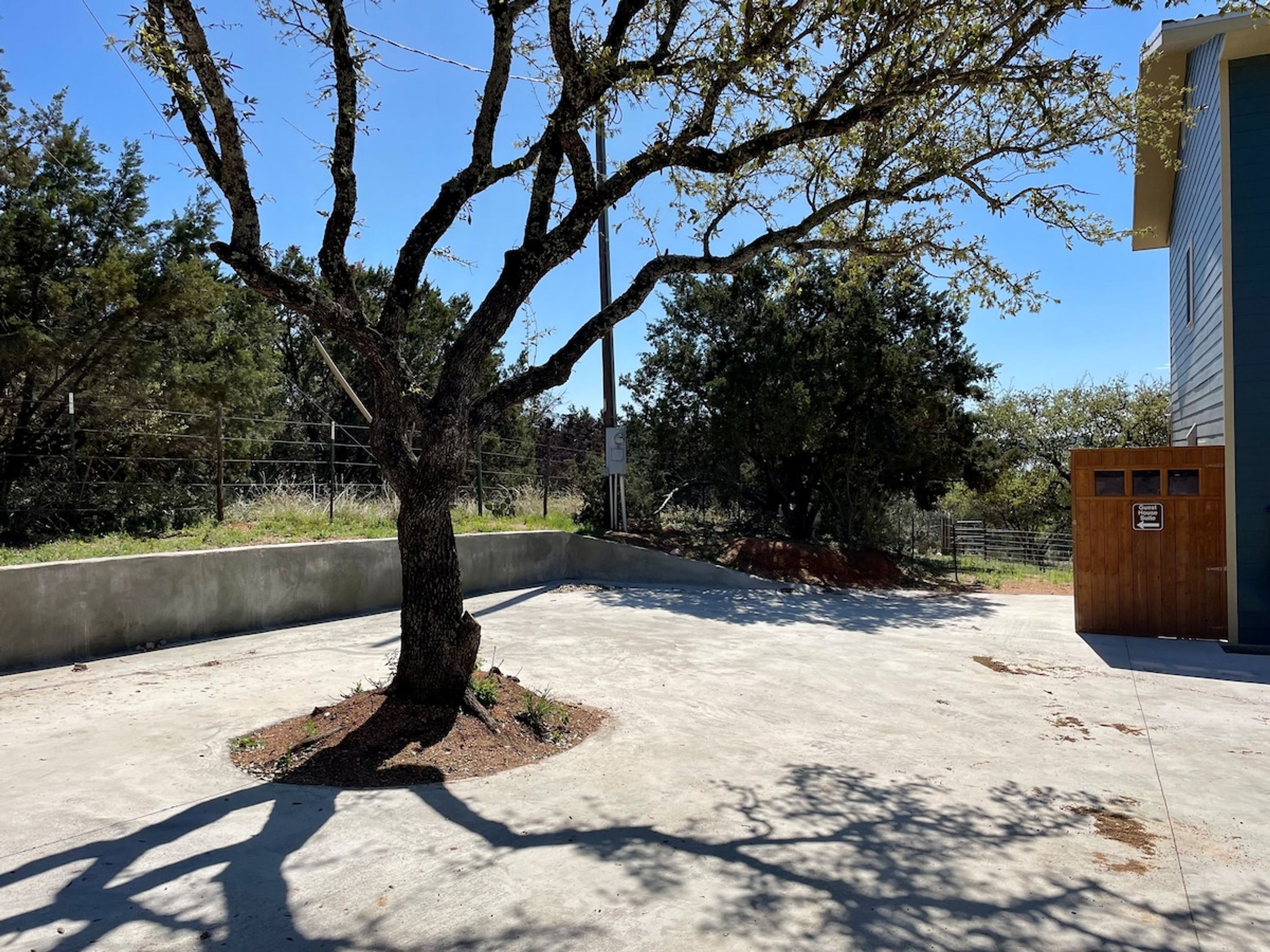 A tree-lined pathway leading to a building with a wooden door labeled "Church of the Open Hand."