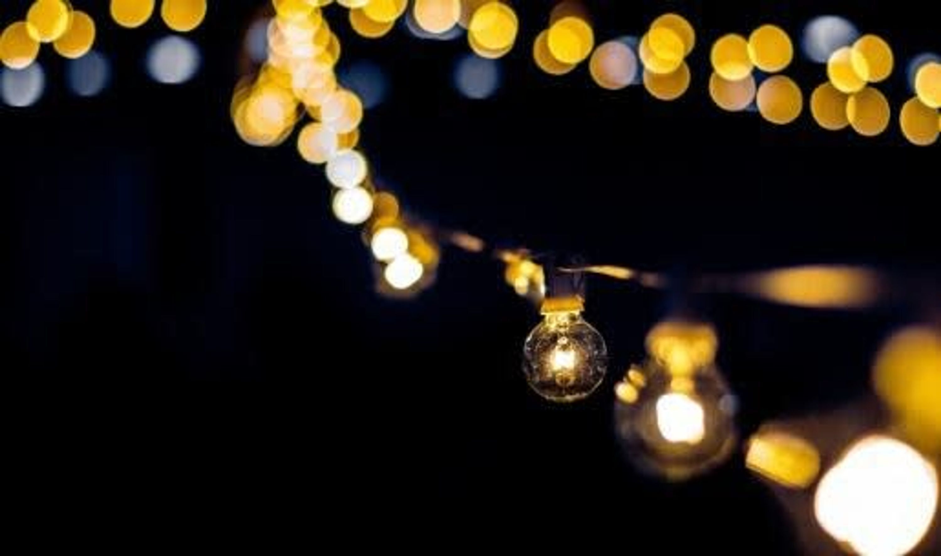 A string of lights with a single bulb in focus.