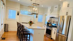 Una cocina moderna con una isla central, electrodomésticos de acero inoxidable y suelo de madera.