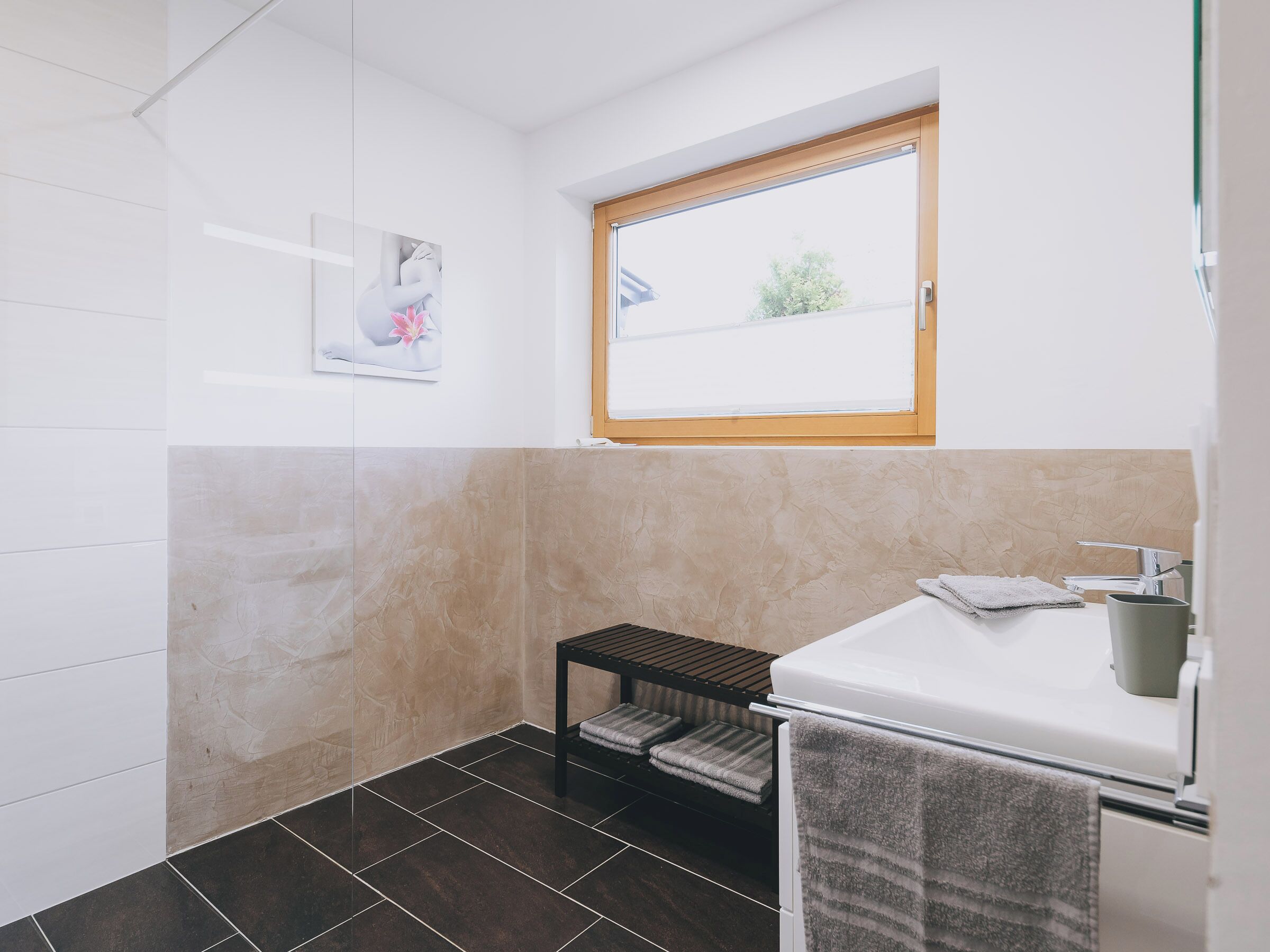 Un baño con ventana, toallero y lavamanos.