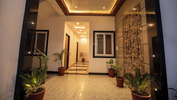 A modern hallway with a wooden ceiling, potted plants, and a stone wall. - Hotel Haridas Haveli Udaipur (Udaipur)
