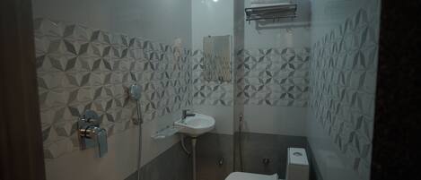 A modern bathroom with geometric patterned tiles, a white sink, and a toilet.